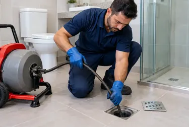 Técnico desentupindo ralo em uma residência de Breves.